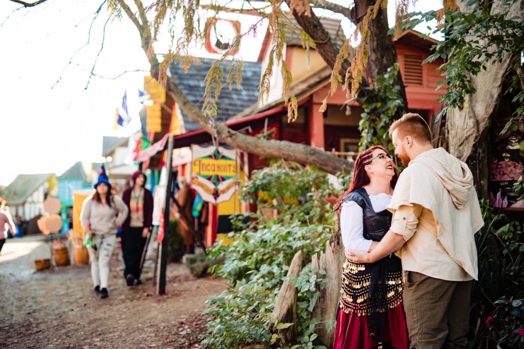 a couple in front of the fairy tree during their engagement photos at the Ohio Renaissance Festival