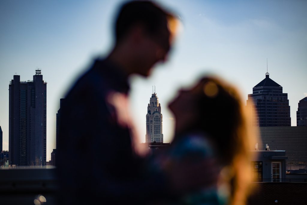 a silhouette of a couple in front of the Columbus skyline