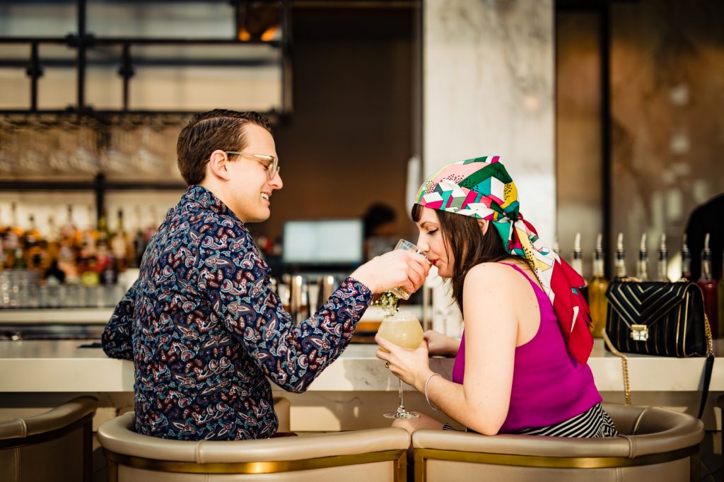 a couple sharing drinks during their Goodale Station engagement photos