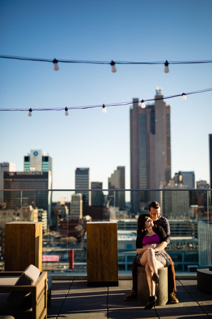 a couple cuddles in front of the Columbus skyline during their Goodale Station engagement photos