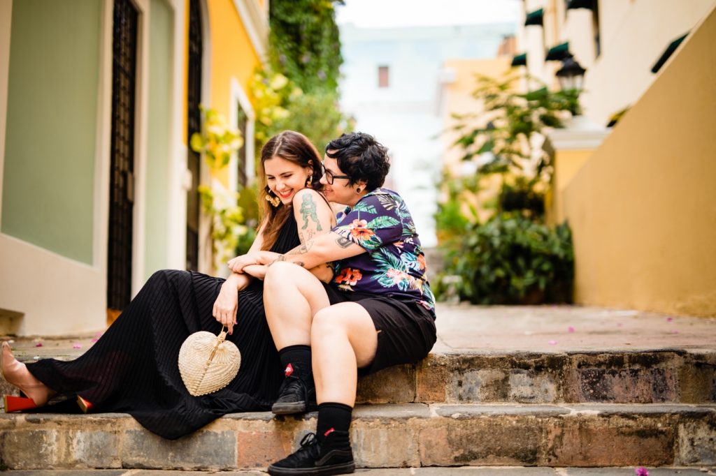 a couple cuddles among the colorful buildings for their San Juan photos