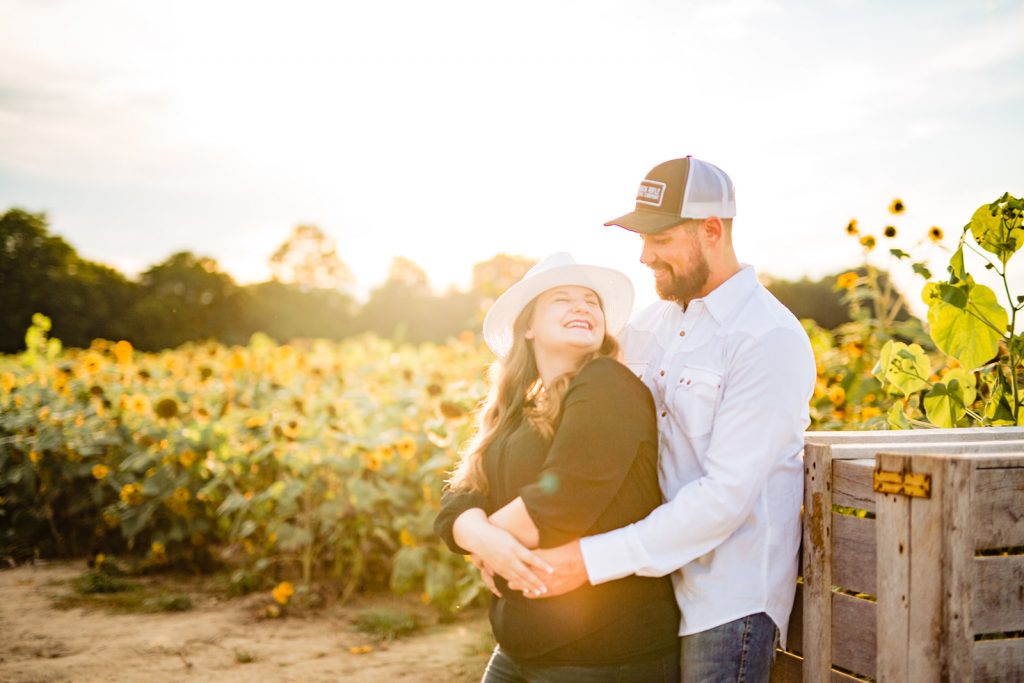 a couple poses for sunflower engagement photos