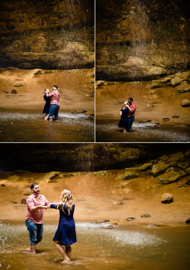a couple plays in the waterfall at Ash Cave during their engagement photos at Hocking Hills