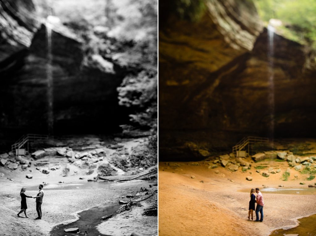 a couple looks at the waterfall at Ash Cave during their engagement photos at Hocking Hills