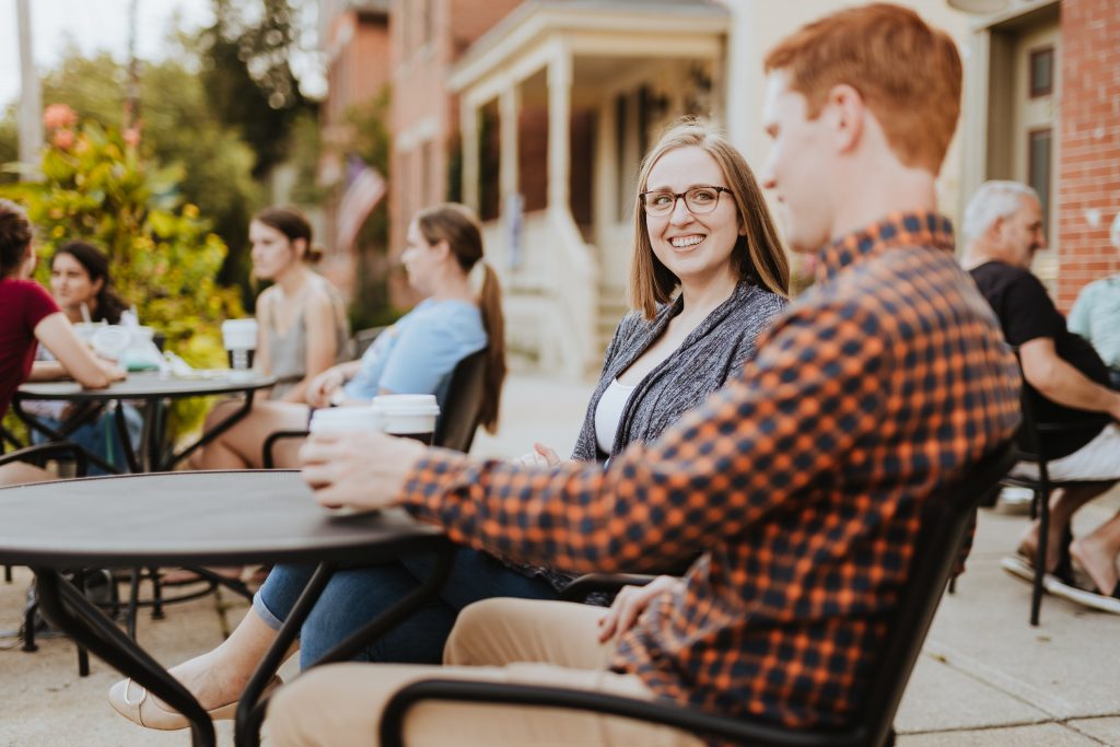 a couple drinks coffee on the Winans Chocolates patio during their German Village engagement photos