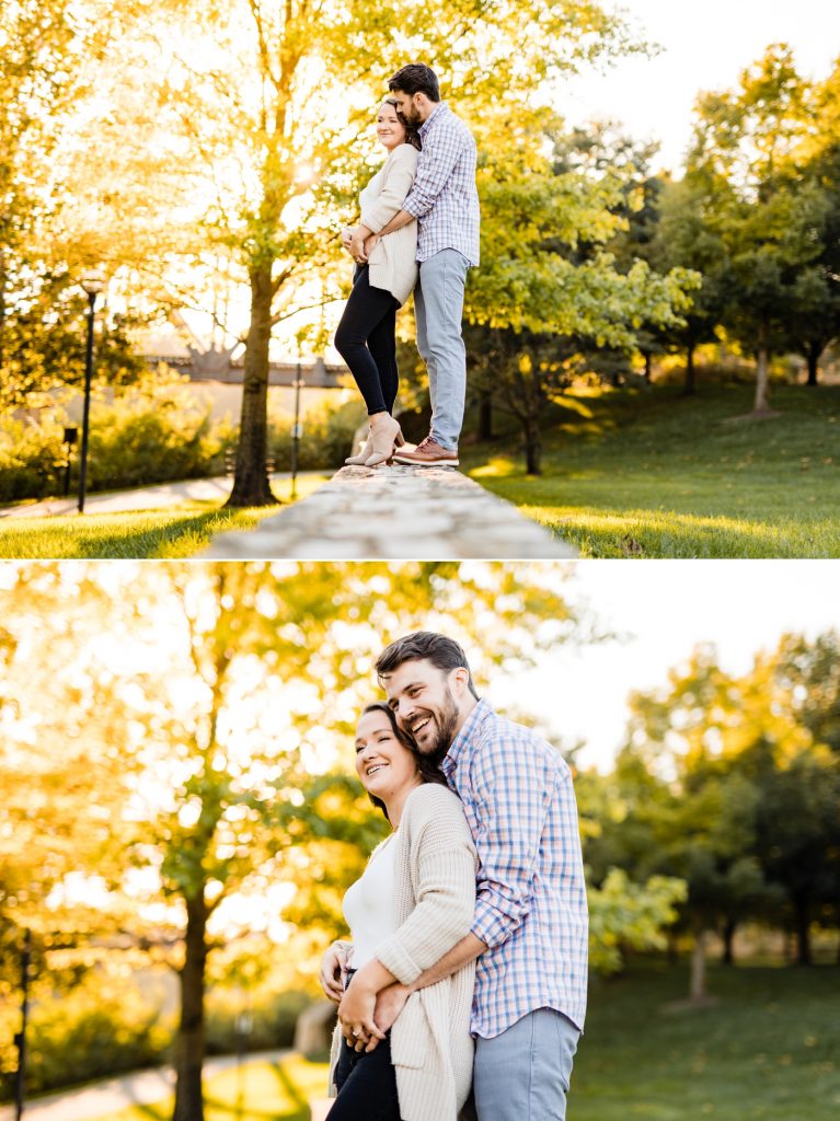 a unique perspective of a couple standing on a wall during their engagement session at North Bank Park
