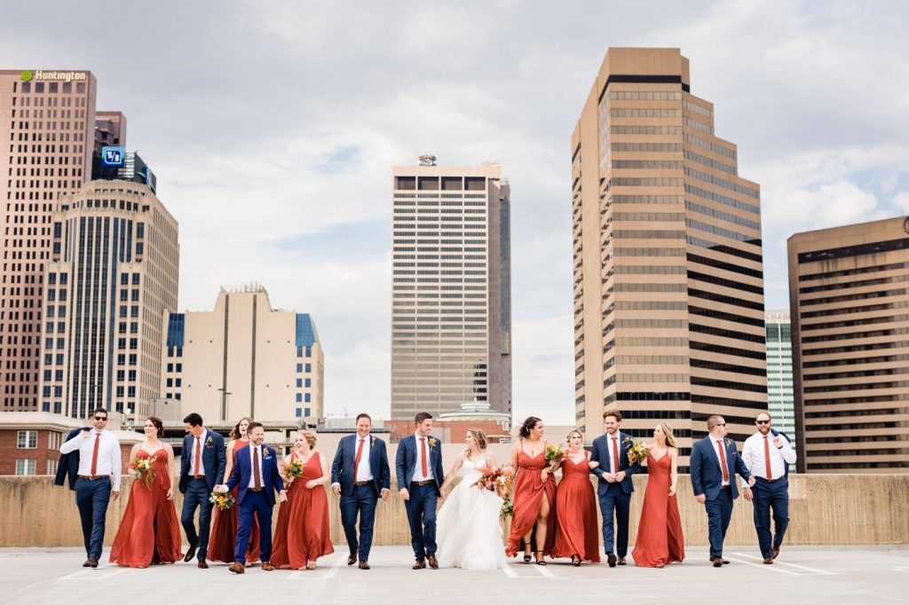 a wedding party walks in front of the Columbus skyline before a wedding at Edison 777
