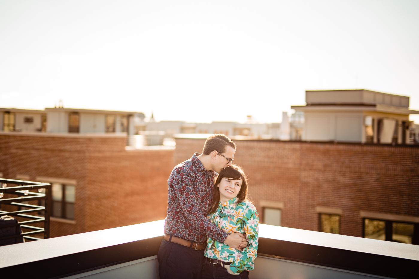 a couple laughs on their rooftop balcony overlooking the city of Columbus