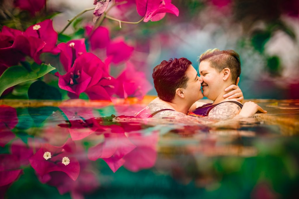 a double exposure of an lgbtq couple kissing and pink flowers during Puerto Rico photos