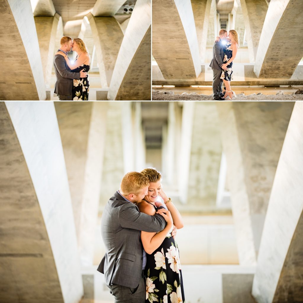 a couple cuddles under the Main Street bridge during their engagement photos at Scioto Mile