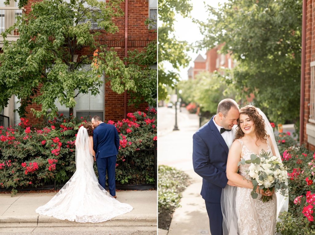 a couple has portraits taken in front of rose bushes before their wedding at The Vue