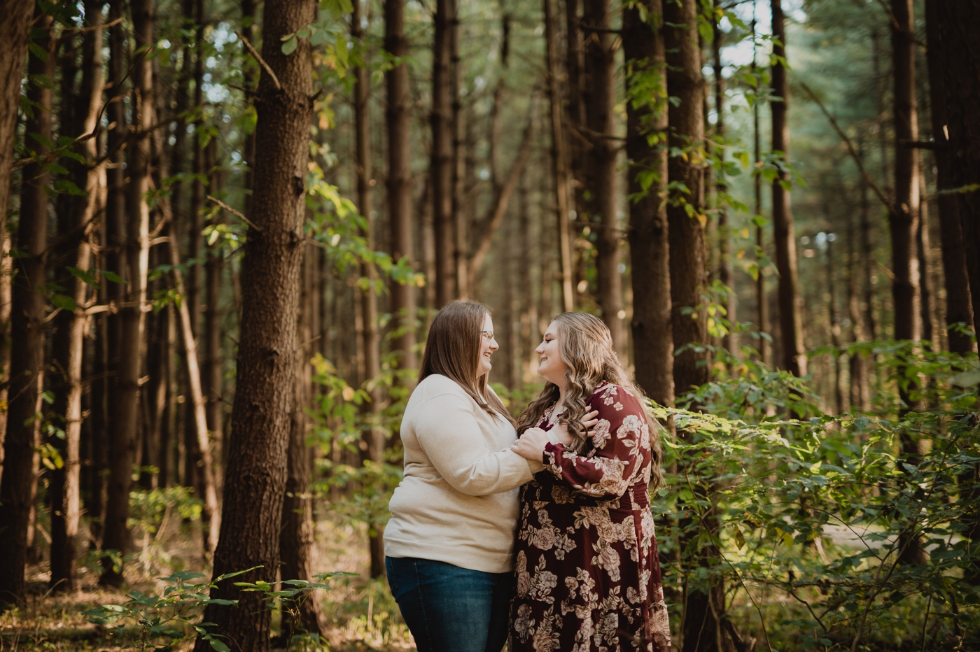 a couple laugh together during their engagement photos at Walnut Woods Tall Pines
