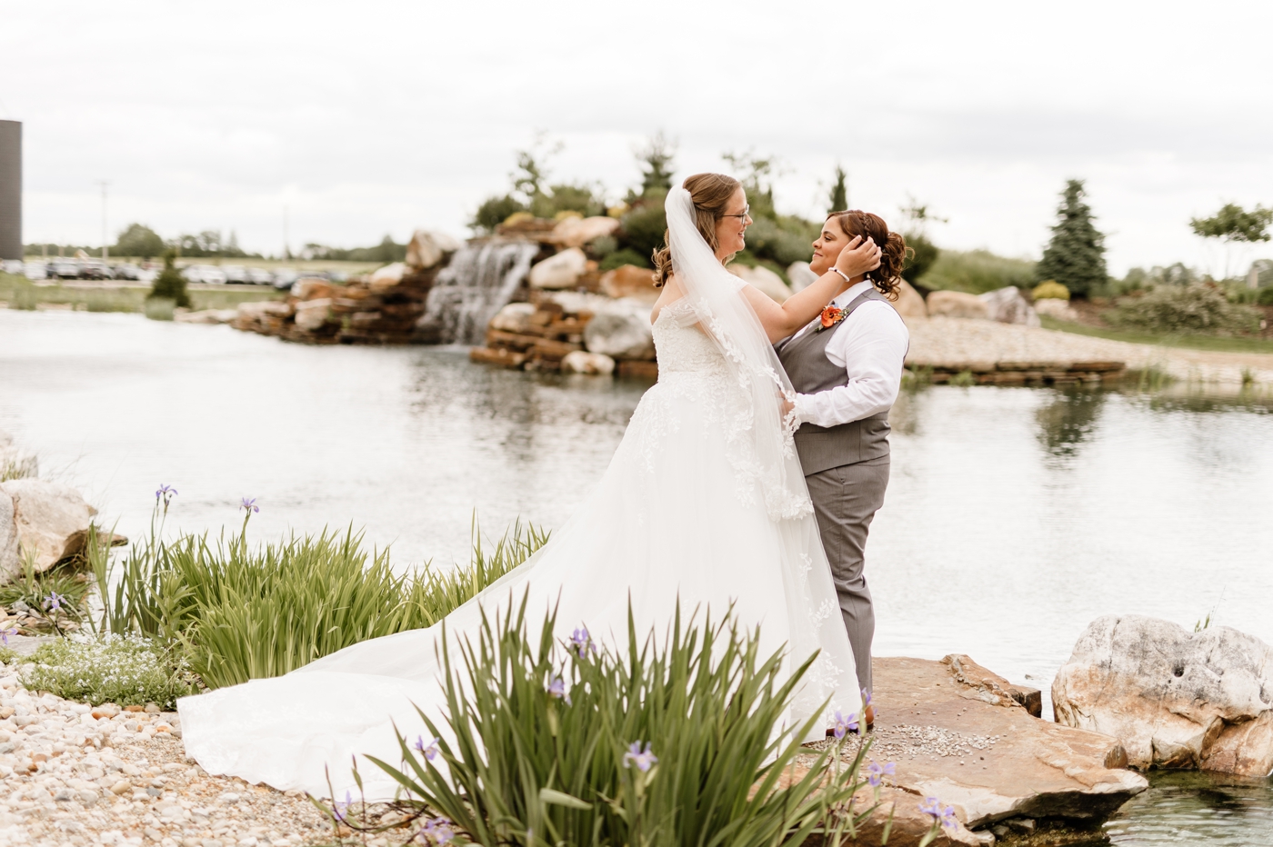 a couple poses in front of the pond at a wedding at Retreat 21